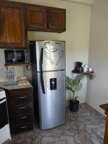 a kitchen with a stainless steel refrigerator in a kitchen at St. George's Holiday Studio Vacation of a lifetime in Fontenoy
