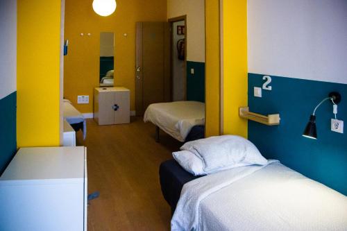 a hospital room with two beds and a mirror at Onefam Sungate in Madrid