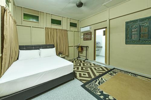 1 dormitorio con cama blanca y puerta de entrada en OYO HOME 90692 Tok Babah Village Homestay en Kampong Sungai Mati