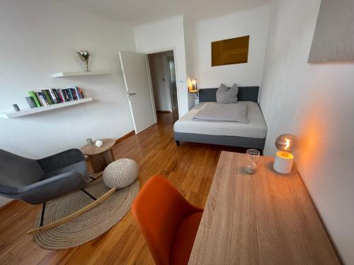 een kleine woonkamer met een bed en een tafel bij Saarland Appartements Losheim-Rimlingen in Rimlingen