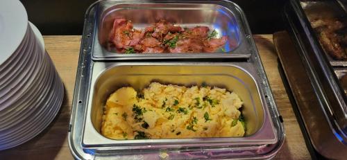 two trays of food on a table with plates at DORMERO Hotel Hannover-Langenhagen Airport in Hannover