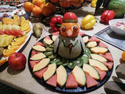 a plate of fruit with a bird on top of it at DORMERO Hotel Hannover-Langenhagen Airport in Hannover