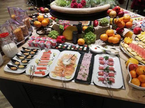 bufet z wieloma różnymi rodzajami żywności na stole w obiekcie DORMERO Hotel Hannover-Langenhagen Airport w Hanowerze