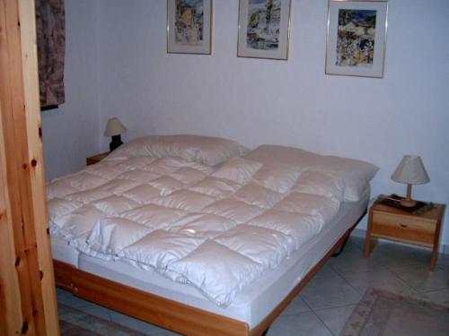 Un dormitorio con una cama con sábanas blancas. en Casa Franci, en Ascona