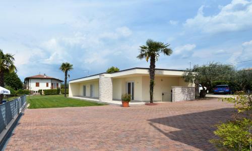 a house with a palm tree in the driveway at Hotel Panoramica in Bardolino