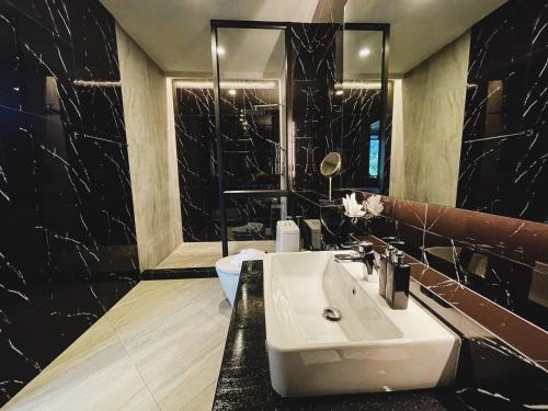 a bathroom with a white sink and a mirror at D’Endless Resotel in Baen