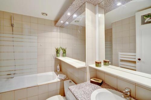 a bathroom with a tub and a sink and a toilet at Le Rétro - Bail Mobilité - cœur des Chartrons in Bordeaux