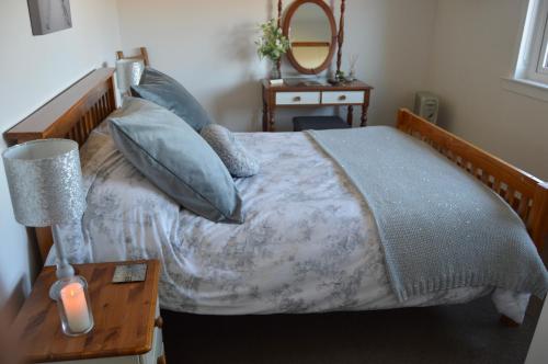 a bedroom with a bed and a table with a lamp at Clunebeg Retreat in Spean Bridge