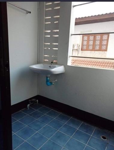 a bathroom with a sink and a window at โชคชัยแมนชั่น บางบัวทอง in Nonthaburi