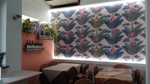 a dining room with tables and flowers on the wall at Hotel Prati in Montecatini Terme