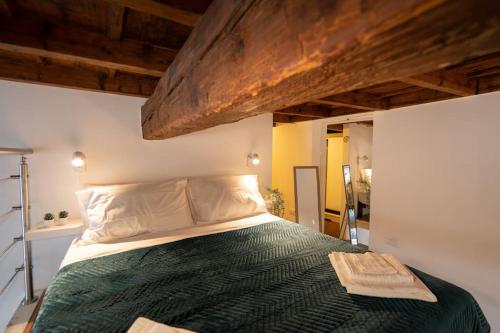 ein Schlafzimmer mit einem Bett mit einer grünen Bettdecke in der Unterkunft [DUOMO WALKING DISTANCE] Central Loft in Mailand