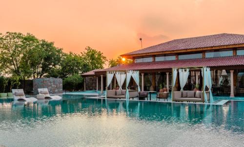 uma piscina de resort com cadeiras e um edifício em Brij Bageecha Jaipur - Private Villas with Plunge Pools em Jaipur