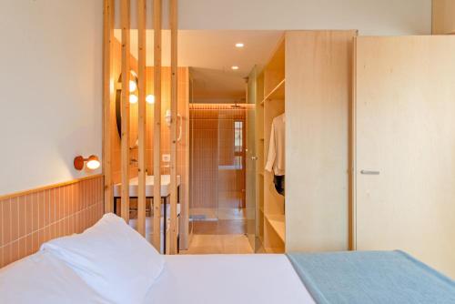 ein Schlafzimmer mit einem Bett und einer ebenerdigen Dusche in der Unterkunft Jardinets De Gràcia by The 5ve Soul in Barcelona