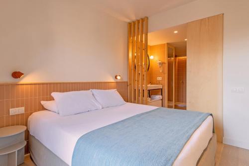 a bedroom with a large bed and a bathroom at Jardinets De Gràcia by The 5ve Soul in Barcelona