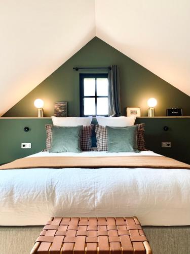 ein Schlafzimmer mit einem großen Bett mit grünen Wänden in der Unterkunft LA CLEF DES CHAMPS 61 in La Chapelle-Souëf