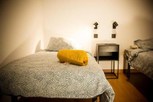 a bedroom with a bed with a yellow blanket on it at Onefam Sungate in Madrid