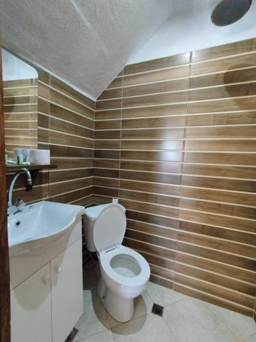 a bathroom with a toilet and a sink at Семеен хотел Скендерова Къща in Leshten