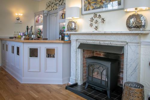 a living room with a fireplace and a counter at Best Western Annesley House Hotel in Norwich