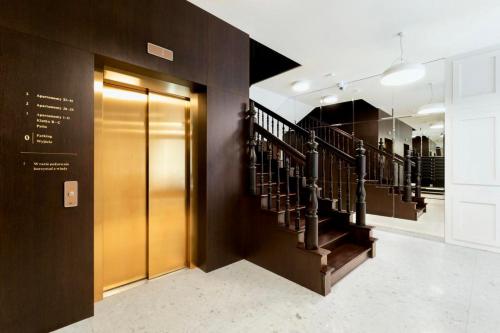 - un ascenseur dans un immeuble avec un escalier dans l'établissement Golden Garden Apartment Tuwima Street, à Łódź
