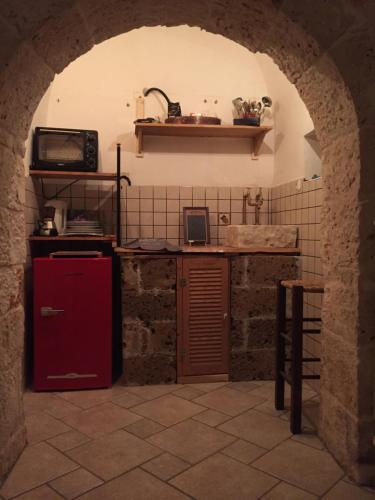 a kitchen with a red refrigerator and a counter at Gasphouse in Castellana Grotte