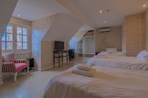 a hotel room with two beds and a television at Casa Daupi in Mar del Plata