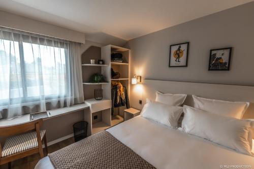 une chambre avec un lit blanc et une fenêtre dans l'établissement Les Hauts de Kerano, à Paimpol