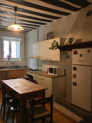 eine Küche mit einem Holztisch und eine Küche mit einem Kühlschrank in der Unterkunft Al Termen in Sondrio
