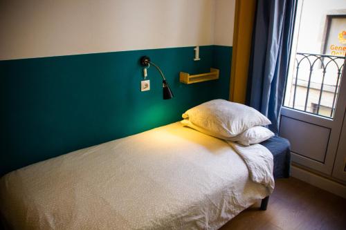 a bed in a room with a green wall at Onefam Sungate in Madrid