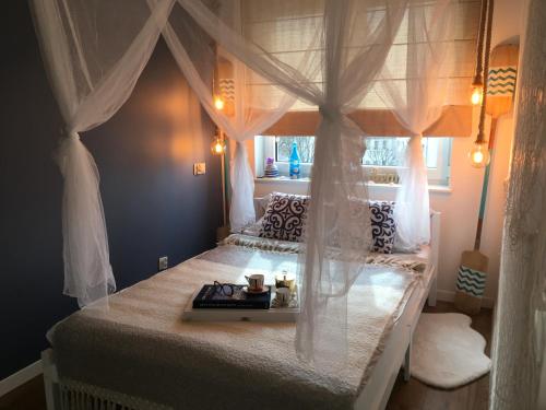 sypialnia z łóżkiem z baldachimem i tacą w obiekcie Apartament Marine Holiday Elbląg - winda -Parking w HALI GARAŻOWEJ -GRATIS -Business stays w Elblągu
