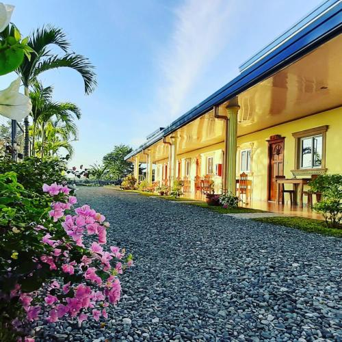 a cobblestone street next to a building with pink flowers at Binalonan Transient/GUESTHOUSE (PENSION GLAYDIE) in Binalonan