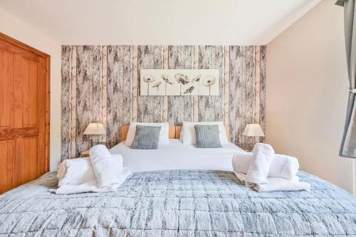 a bedroom with a large white bed with two chairs at 3 bed Lodge with EV point in Truro