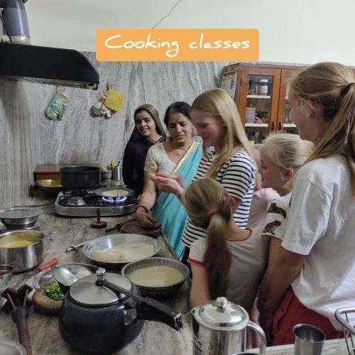 a group of people in a kitchen preparing food at Tourist Pension in Nawalgarh