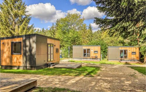 two modular homes in a park with trees at Tiny Haus 49 Am Brombachsee in Pleinfeld