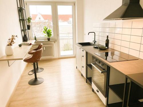 a kitchen with a stove and a chair in it at Altstadt-Wohnung im Weidener Zentrum in Weiden