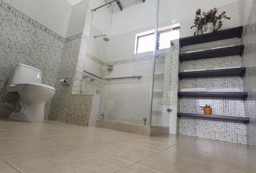 La salle de bains est pourvue d'une douche et de toilettes. dans l'établissement VILLA ALEJANDRA - Hermosa FINCA cerca al centro - Sendero - Jacuzzi, à Popayan