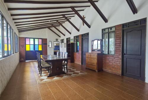 a room with a table and chairs and a brick wall at VILLA ALEJANDRA - Hermosa FINCA cerca al centro - Sendero - Jacuzzi in Popayan