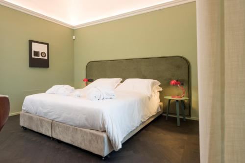 a bedroom with a large bed with white sheets and pillows at MoLo Suites in Monopoli