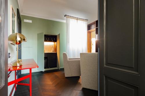 a living room with a red table and a kitchen at MoLo Suites in Monopoli