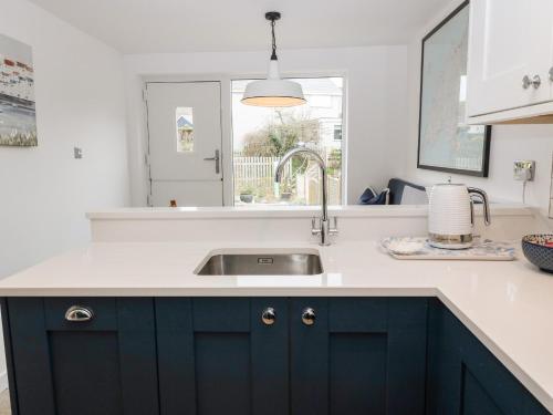 a kitchen with blue cabinets and a sink at Arwel in Pwllheli