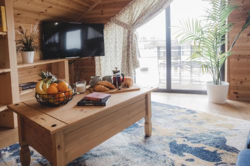 a living room with a table with fruit on it at Woodlakes Park By Liv Retreats in Kings Lynn