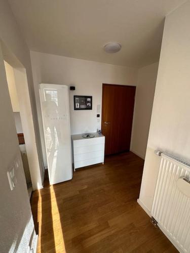 pusty pokój z drzwiami i drewnianą podłogą w obiekcie Zentrales Appartement Ottobrunn w mieście Ottobrunn