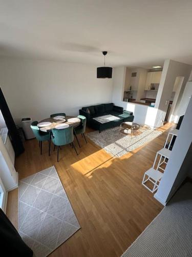 salon z kanapą, stołem i krzesłami w obiekcie Zentrales Appartement Ottobrunn w mieście Ottobrunn