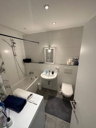 a bathroom with a sink and a toilet and a tub at Zentrales Appartement Ottobrunn in Ottobrunn