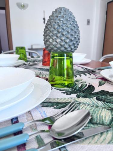 a table with white plates and spoons on it at Appartamento il sole 2 piano in Realmonte