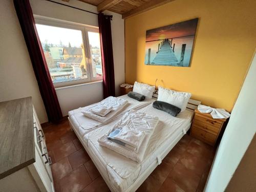 a bedroom with a bed with white sheets and a window at Haus Krabbe mit Strandkorb inkl in Göhren