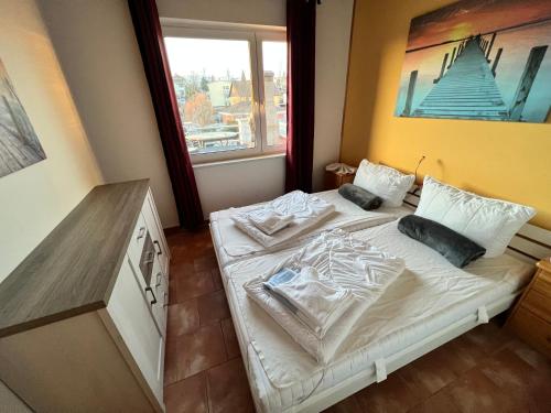 a small bedroom with a bed with white sheets and pillows at Haus Krabbe mit Strandkorb inkl in Göhren
