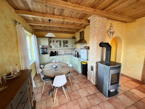 a kitchen with a table and a wood stove at Haus Krabbe mit Strandkorb inkl in Göhren