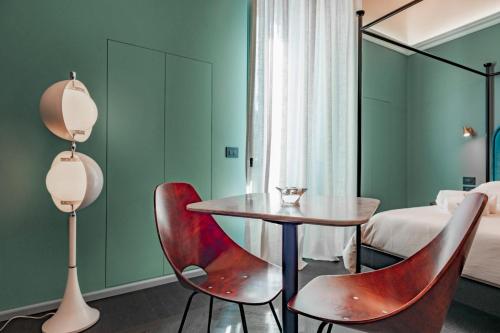 a room with a table and two chairs and a bed at MoLo Suites in Monopoli