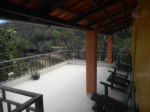 a porch with two chairs and a balcony at Pousada do Ceu in Paul