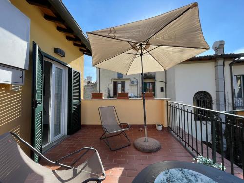 un patio con ombrellone e sedia sul balcone di Appartamento Firenze Centro Amorino con terrazzo a Firenze